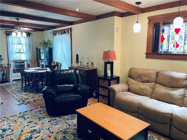 living room with ceiling fan, beamed ceiling, and hardwood / wood-style floors