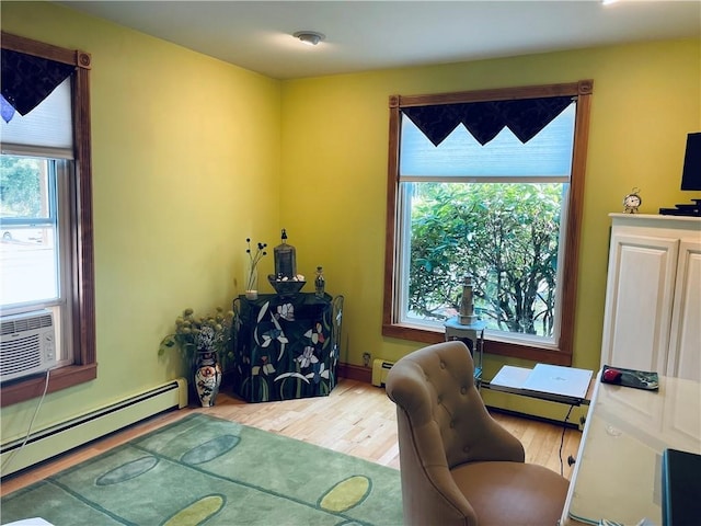 home office with a baseboard radiator, hardwood / wood-style floors, and a wealth of natural light