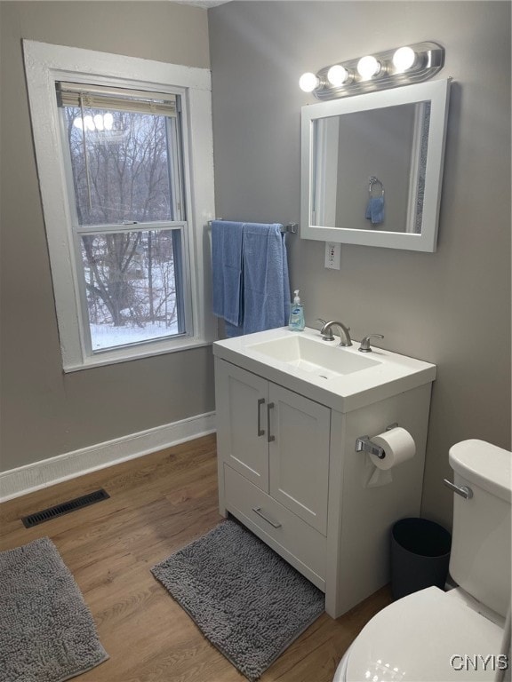 bathroom with hardwood / wood-style floors, vanity, and toilet