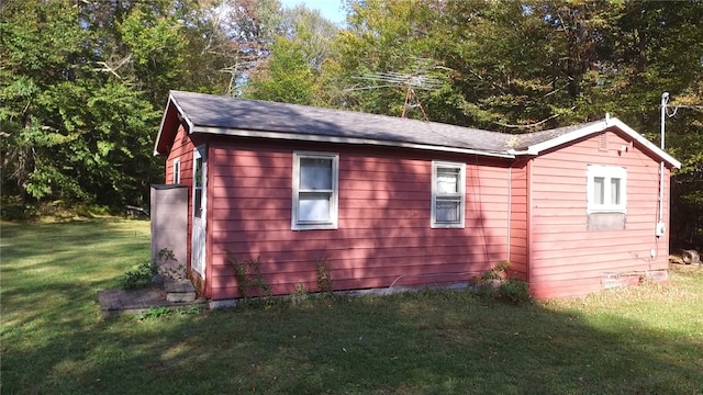 view of property exterior with an outdoor structure and a lawn