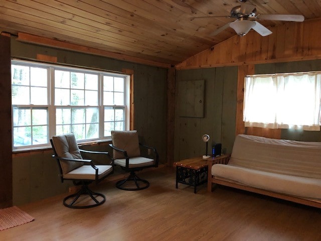 living area featuring wood-type flooring, wood ceiling, vaulted ceiling, and ceiling fan