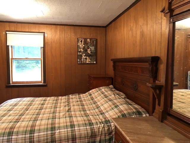 bedroom featuring a textured ceiling and wooden walls