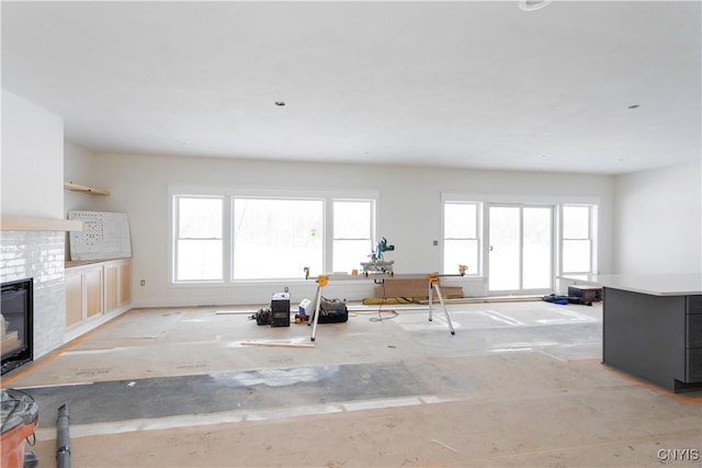 kitchen with plenty of natural light, light countertops, dark cabinetry, and a brick fireplace