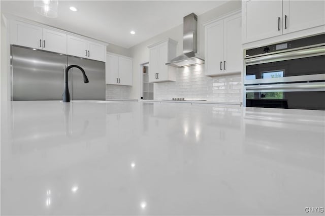 LOT58 Chillingham Way, Lysander, NY 13027 - kitchen with wall chimney exhaust hood, stainless steel appliances, decorative backsplash, white cabinetry, and recessed lighting