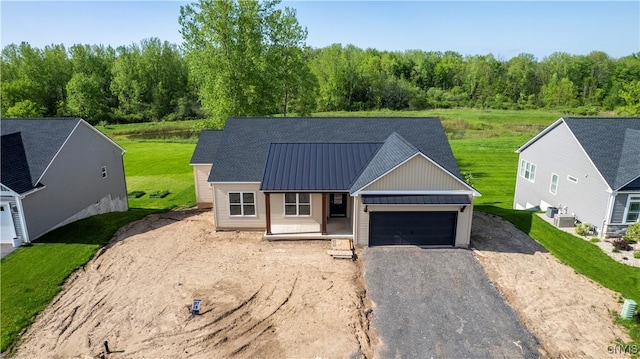 LOT58 Chillingham Way, Lysander, NY 13027 - view of front of property with dirt driveway, a garage, metal roof, board and batten siding, and a view of trees