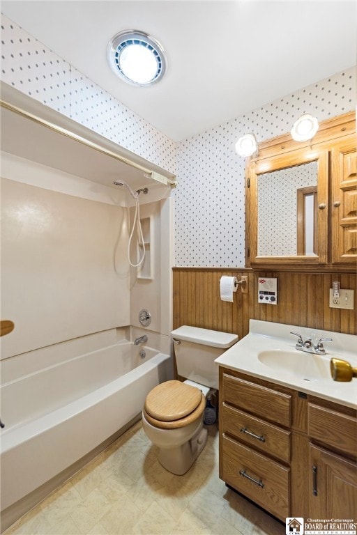 full bathroom with wooden walls, vanity, shower / tub combination, and toilet