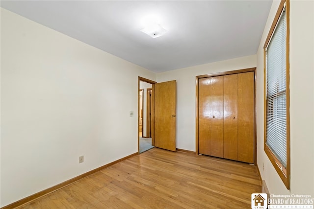 unfurnished bedroom featuring a closet and light hardwood / wood-style floors