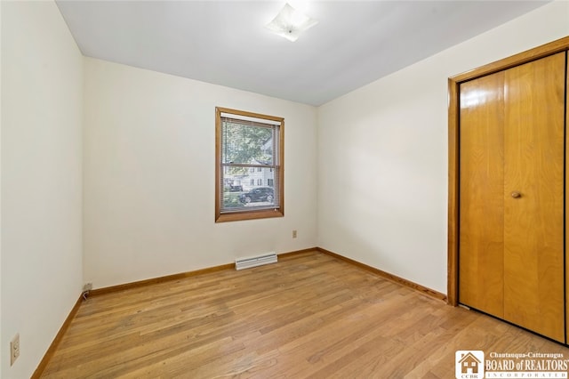 unfurnished bedroom with a closet and light hardwood / wood-style floors