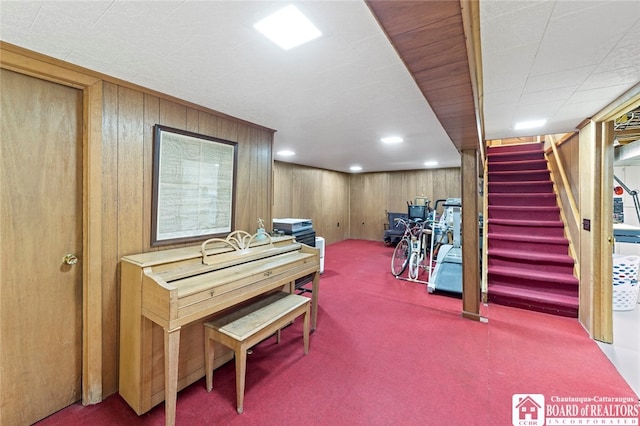 miscellaneous room featuring wood walls and carpet