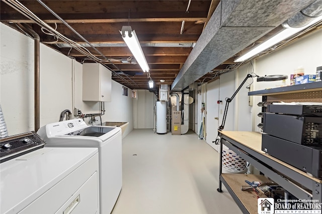 clothes washing area with gas water heater, separate washer and dryer, sink, and heating unit