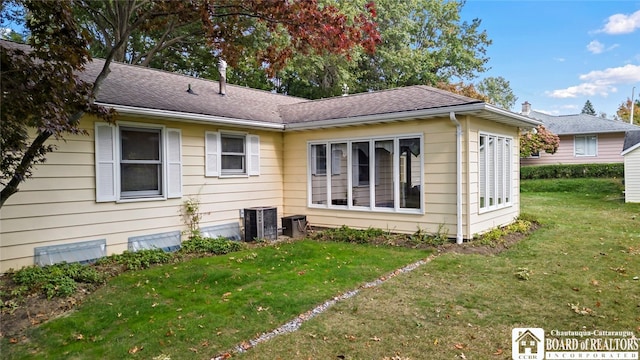 back of property with a yard and central air condition unit