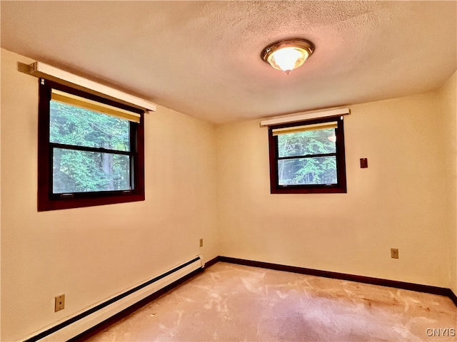 carpeted spare room featuring a textured ceiling and a baseboard radiator