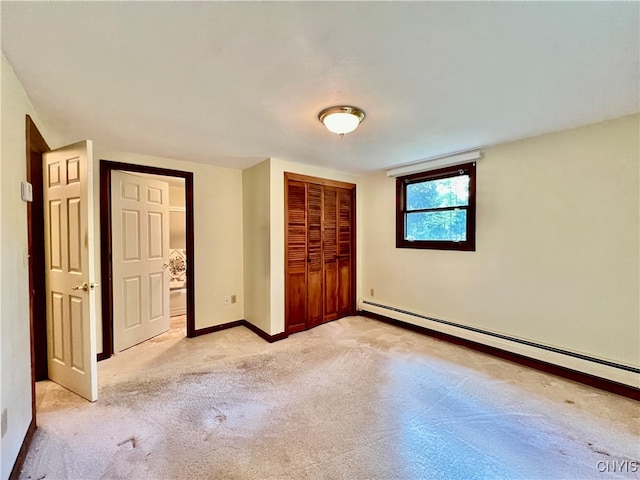 unfurnished bedroom with a closet, light colored carpet, and a baseboard heating unit