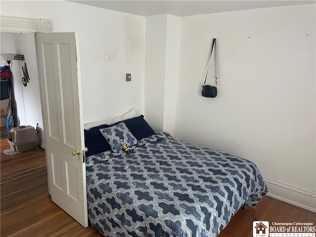 bedroom with dark wood-type flooring