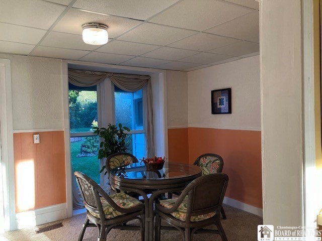 dining area featuring a paneled ceiling and carpet floors