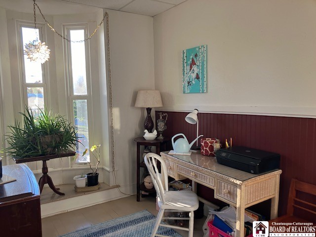 home office featuring a paneled ceiling and tile patterned flooring