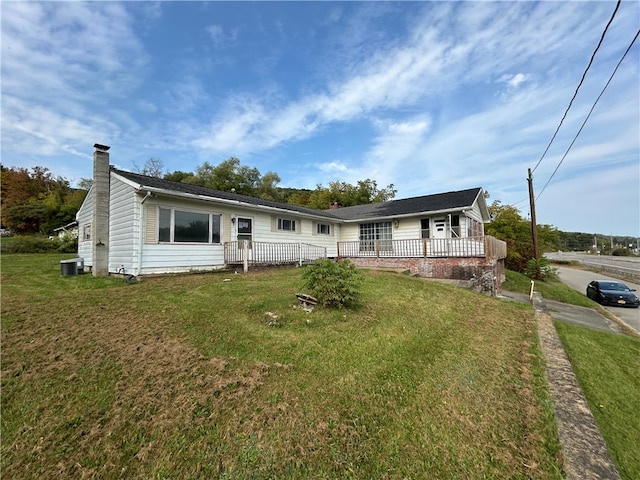 ranch-style house featuring a front yard and cooling unit