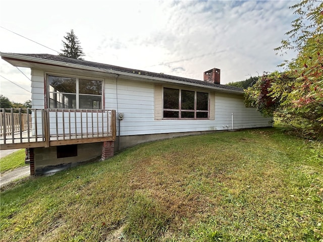 rear view of house with a lawn and a deck