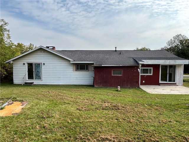 rear view of house featuring a lawn and a patio