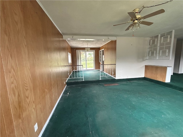 interior space with wood walls and ceiling fan