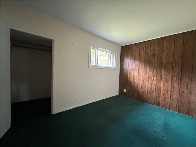 empty room with wood walls and dark carpet