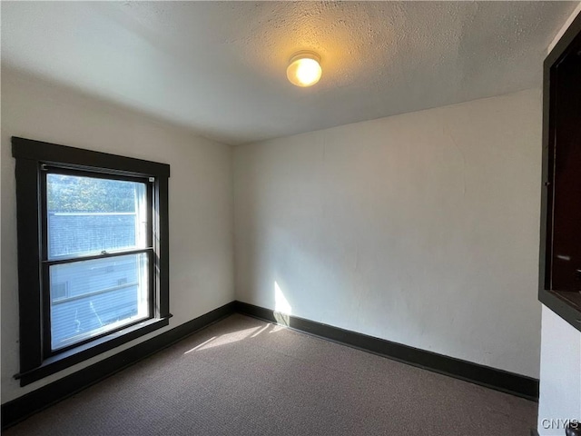 carpeted spare room featuring a textured ceiling