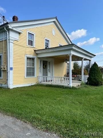 back of house with a yard and a porch