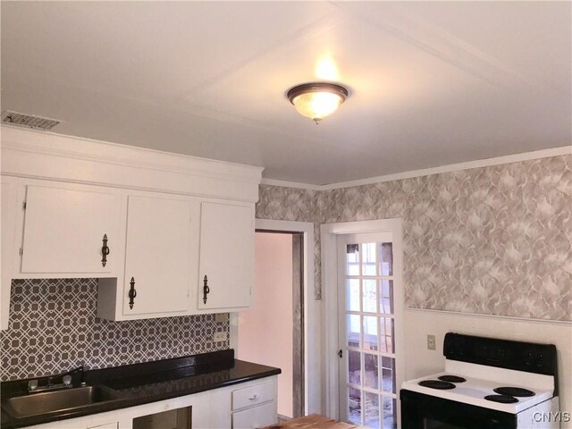 6179 State Highway 29a, Stratford, NY 13329 - kitchen with electric stove, white cabinets, dark countertops, and wallpapered walls