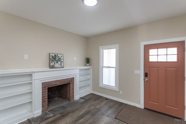 foyer entrance with a fireplace and dark hardwood / wood-style flooring