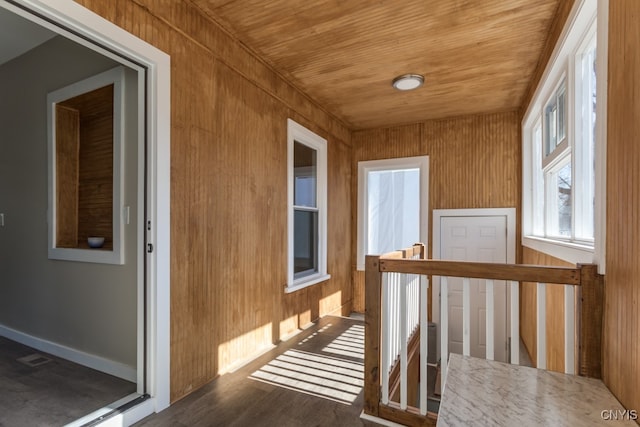 interior space featuring wood walls, dark wood-type flooring, and wooden ceiling