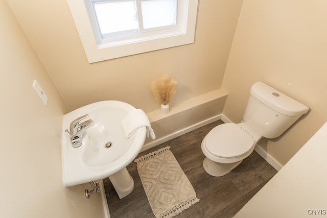 bathroom with hardwood / wood-style flooring and toilet