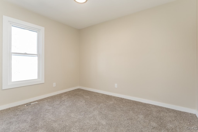 unfurnished room featuring light carpet