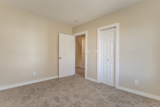 unfurnished bedroom with a closet and light carpet