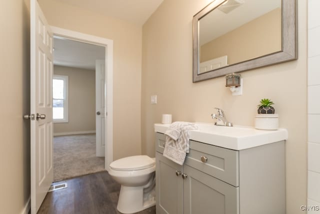 bathroom featuring vanity, toilet, and hardwood / wood-style flooring