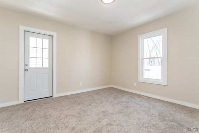 unfurnished room featuring light colored carpet and a wealth of natural light