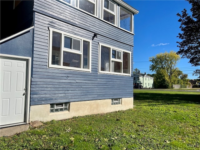 view of side of home with a yard