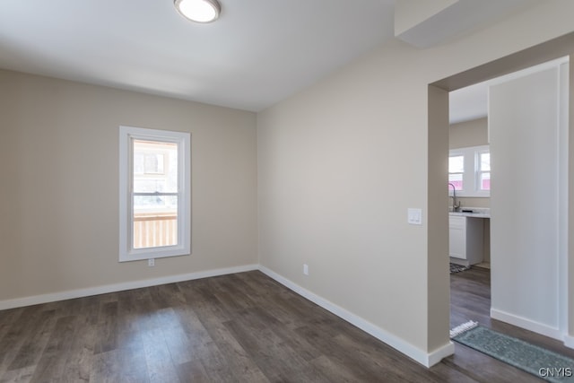 unfurnished room with dark hardwood / wood-style floors and sink