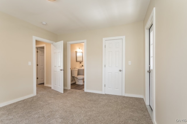 unfurnished bedroom featuring a closet, connected bathroom, and carpet flooring