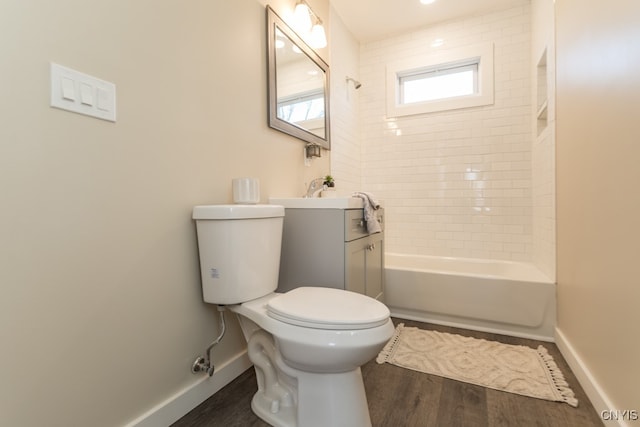 full bathroom featuring hardwood / wood-style flooring, vanity, toilet, and tiled shower / bath