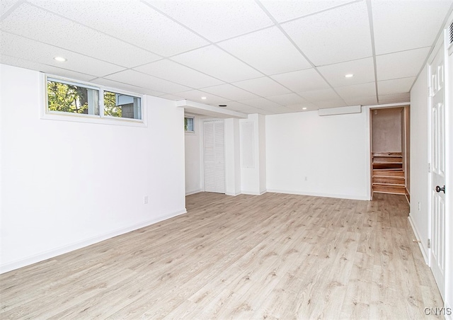 basement with light wood-type flooring and a drop ceiling