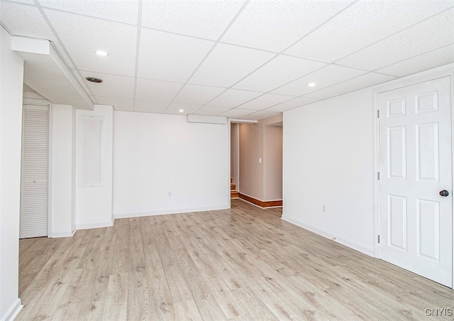 basement featuring a drop ceiling and light hardwood / wood-style floors