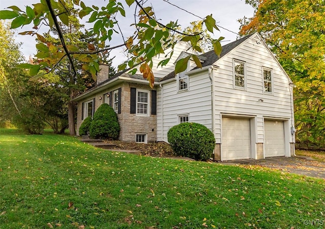 view of property exterior with a garage and a lawn