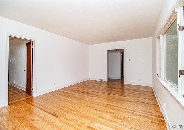 spare room featuring plenty of natural light and light hardwood / wood-style floors