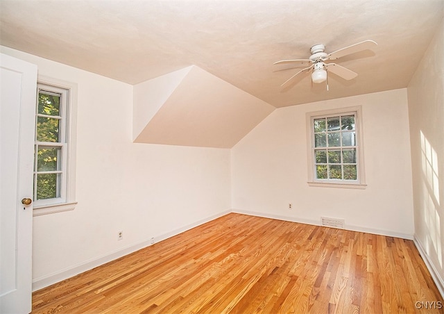 bonus room with ceiling fan, lofted ceiling, light hardwood / wood-style floors, and a healthy amount of sunlight