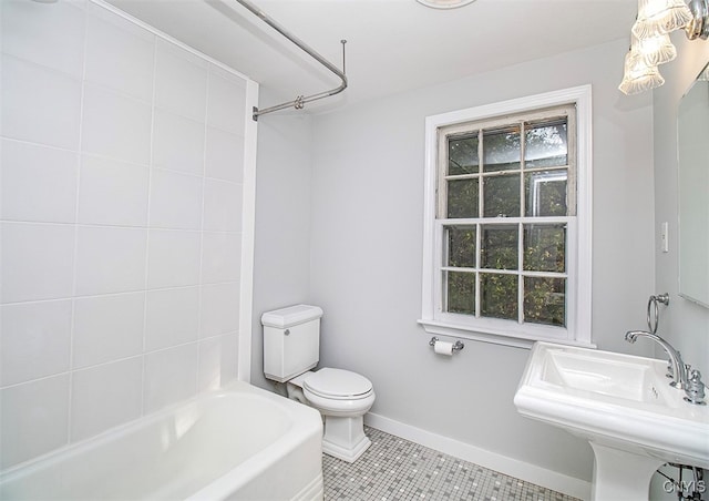 full bathroom with sink, tiled shower / bath combo, toilet, and tile patterned flooring