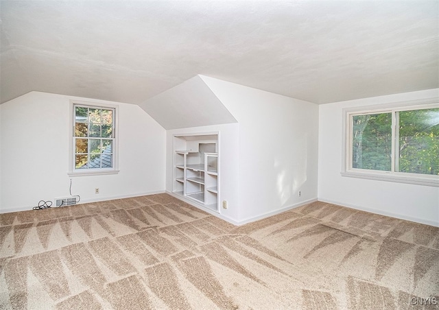 bonus room featuring lofted ceiling and carpet floors