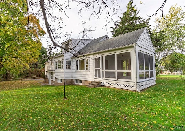 rear view of house featuring a yard and a sunroom