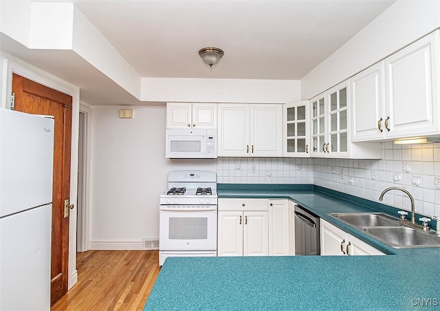 kitchen with white cabinets, light wood-type flooring, sink, and white appliances