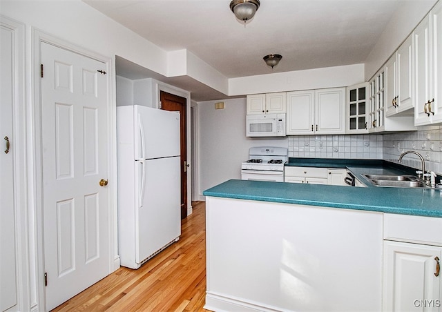 kitchen featuring white cabinets, white appliances, sink, light hardwood / wood-style flooring, and backsplash