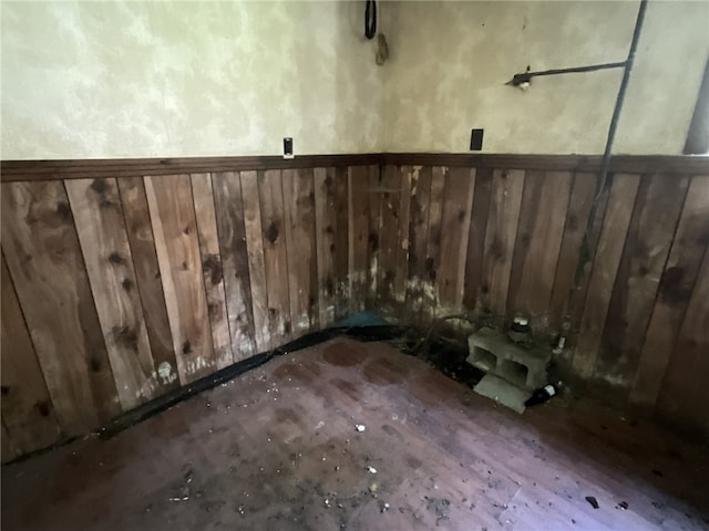 laundry room with wooden walls and hardwood / wood-style floors